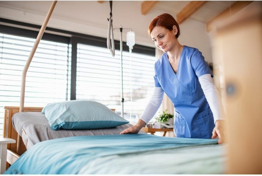 Female nurse changing sheets